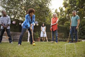 A family playing croquet in a garden